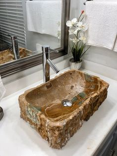 a bathroom sink made out of wood in front of a mirror