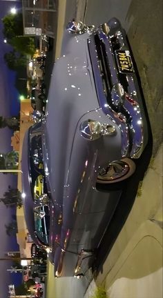 a car parked on the side of a road next to a tall building at night