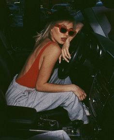 a woman sitting in the driver's seat of a car