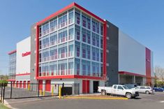 an empty parking lot in front of a multi - story building with cars parked outside