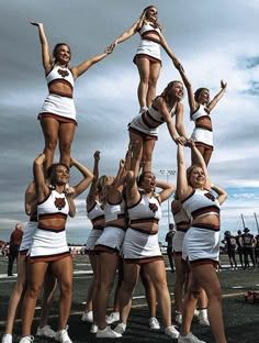 a group of cheerleaders doing stunts on the tarmac