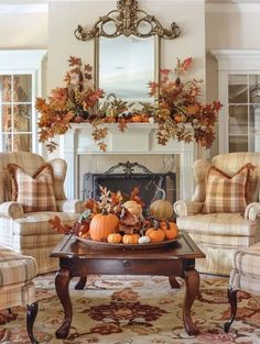 a living room filled with furniture and a fire place covered in pumpkins on top of a coffee table