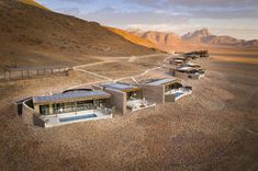 an aerial view of a house in the desert with mountains in the backgroud