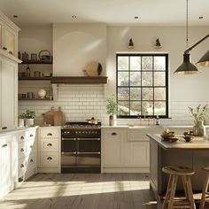 a kitchen with an oven, stove and stools next to the counter top in front of a window