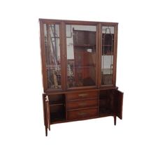 an old wooden china cabinet with glass doors and drawers on the front, against a white background