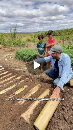 two children and an older man are working in the garden with some wood planks