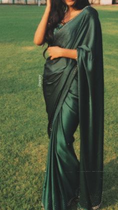 a woman in a green sari posing for the camera