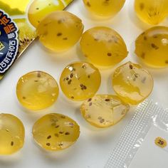 several pieces of yellow jelly sitting on top of a white table next to a packet of gummy bears