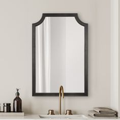 a bathroom sink with a mirror above it and soap dispenser next to it