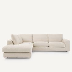 a white sectional couch with pillows on it's back and the seat folded out