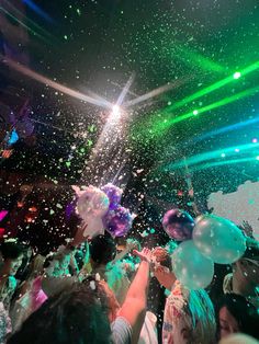 confetti is thrown into the air as people dance in front of them at a party