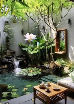 a small pond in the middle of a patio with water lilies and greenery