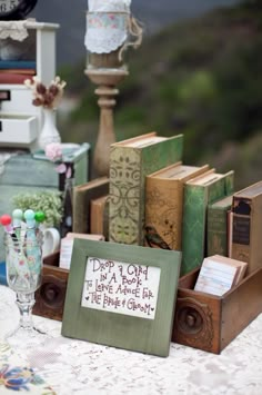 a table topped with lots of books on top of a white cloth covered tablecloth