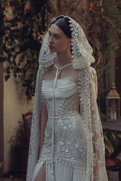 a woman in a white wedding dress with a veil on her head and long sleeves