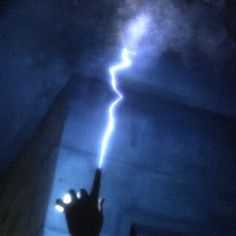 a hand pointing at a lightning bolt in the sky