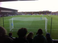 a group of people watching a soccer game from the stands at an outdoor stadium,