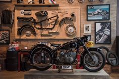 an old motorcycle is on display in a room with many framed pictures and other memorabilia