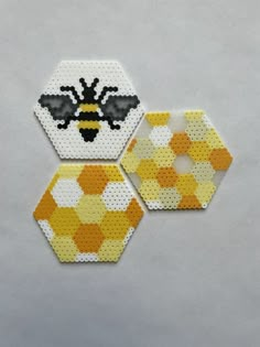 three hexagons made out of perforated materials, each with a bee on them