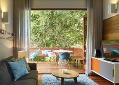 a living room filled with furniture and a flat screen tv sitting on top of a wooden floor