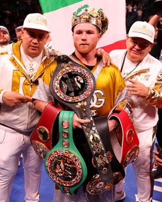 two men standing next to each other holding up their belts in front of a crowd