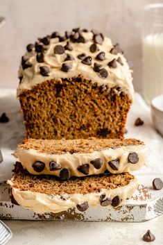 a loaf of cake with frosting and chocolate chips sitting on top of a table