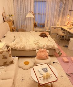 a living room filled with white furniture and lots of pillows on top of the floor