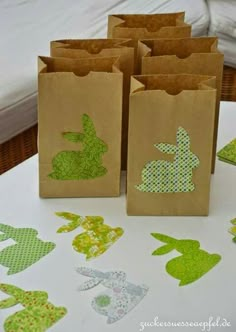 small bags with bunny silhouettes on them sitting on a table next to paper cut outs