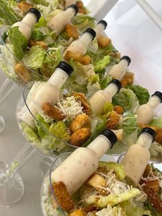 several salads with dressing on them are lined up in glass bowls and ready to be served