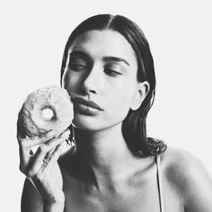 a woman holding a doughnut up to her face