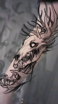 an artistic tattoo design on the arm of a man with a dragon head and horns