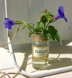 a mason jar filled with purple flowers sitting on top of a table