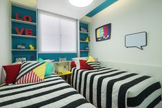 two twin beds with black and white bedding in a room that has blue walls