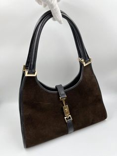 A stunning vintage Gucci Jackie bag made from brown suede, black leather with gold hardware. Inside the bag is lined with a very special gold nylon lining and there is a zipped pocket for valuables. This bag is in very good vintage condition. There are some slight marks to the suede and minor wear to be seen on the gold hardware. A true collectors item, increasingly hard to find the vintage Jackie bag's with gold hardware. This bag also comes with its original Gucci dust bag. Vintage Gucci Jackie, Gucci Collection, Kelly Bag, Pretty Bags, Mode Inspo, 가을 패션, Vintage Bags, Brown Suede, Gucci Jackie Bag