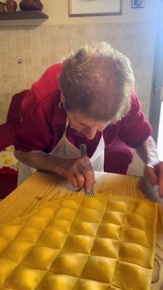 an older woman is working on some food