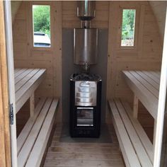 the inside of a small building with benches and a coffee pot on top of it