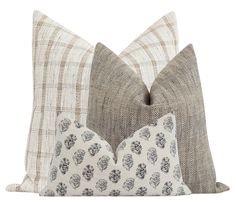 three pillows with different patterns on them, one in grey and the other in white