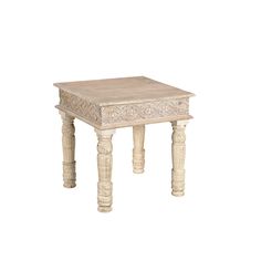 a small wooden table with carvings on the top and bottom, sitting against a white background