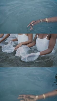 two women in white swimsuits floating on their stomachs and holding hands out to each other