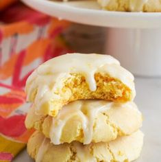 a stack of frosted cookies sitting on top of a white plate