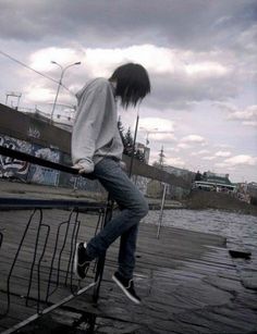 a person riding a skateboard on top of a metal hand rail near the water