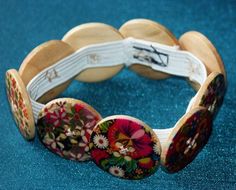 a close up of a wooden bracelet with flowers on it