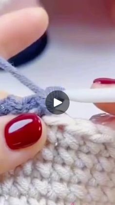 someone is crocheting something with red and white yarn on their thumbnails