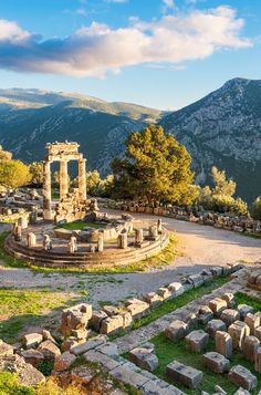 the ancient ruins are surrounded by greenery and trees, with mountains in the background