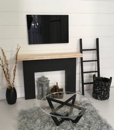 a living room with a glass table and black chair in front of the fire place