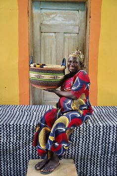 a woman sitting on a bench holding a basket