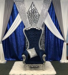 a fancy blue chair with silver sequins on the back and white drapes