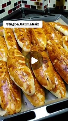 there are many breads on the tray ready to be cooked in the oven for sale