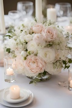 a centerpiece with white and pink flowers on a table set for a formal dinner