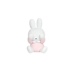 a white and pink stuffed animal sitting on top of a white floor next to a wall