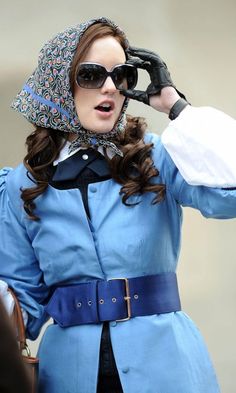 a woman wearing sunglasses and a blue coat